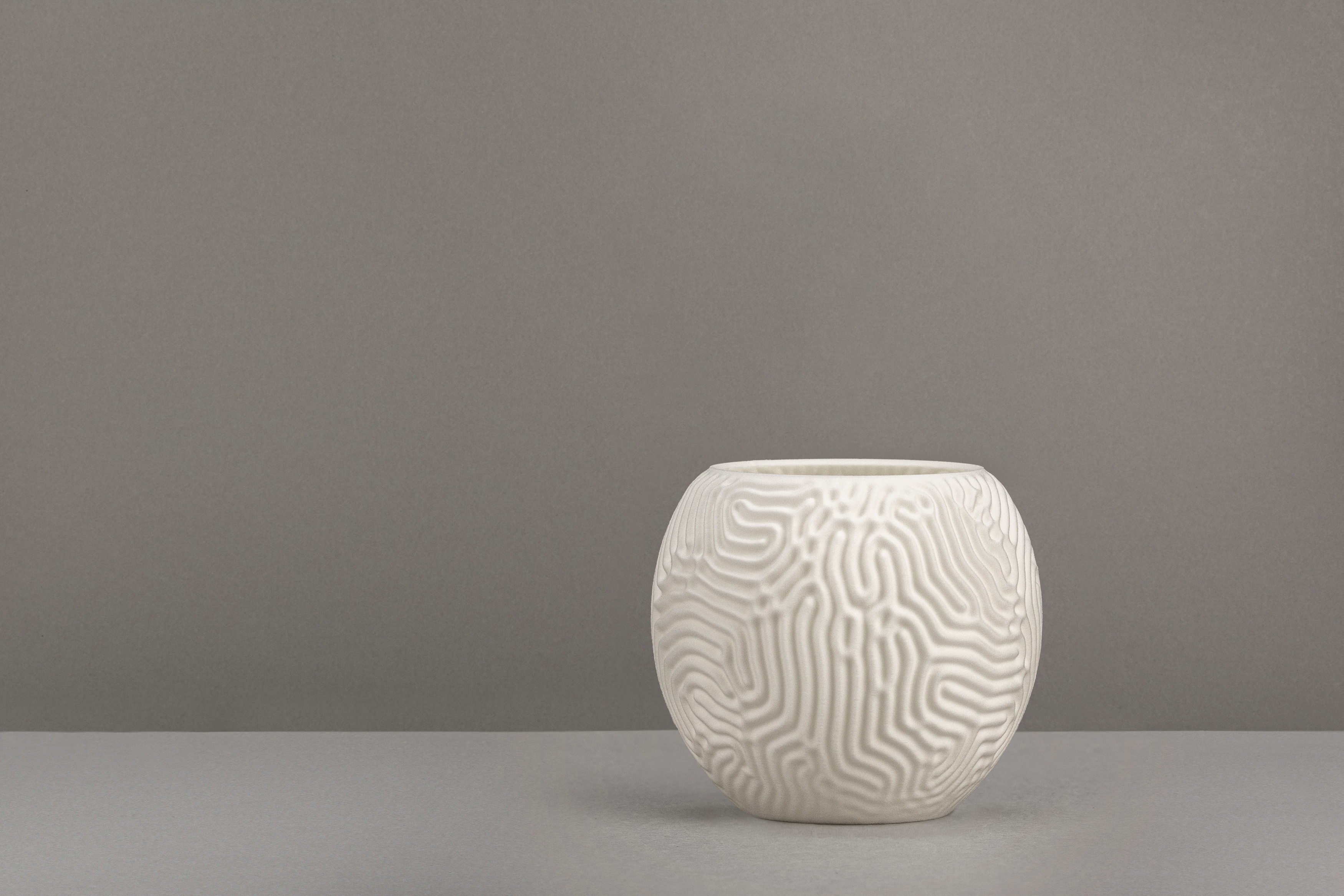 Decorative suggestion for Aeolian Plains: Tealight holder with a nature-inspired design. Evokes reveries of dune patterns - variant Original (Elegant white), an original product by Cosmic Jubilee (2 of 3) - presented as a tealight, switched off.
