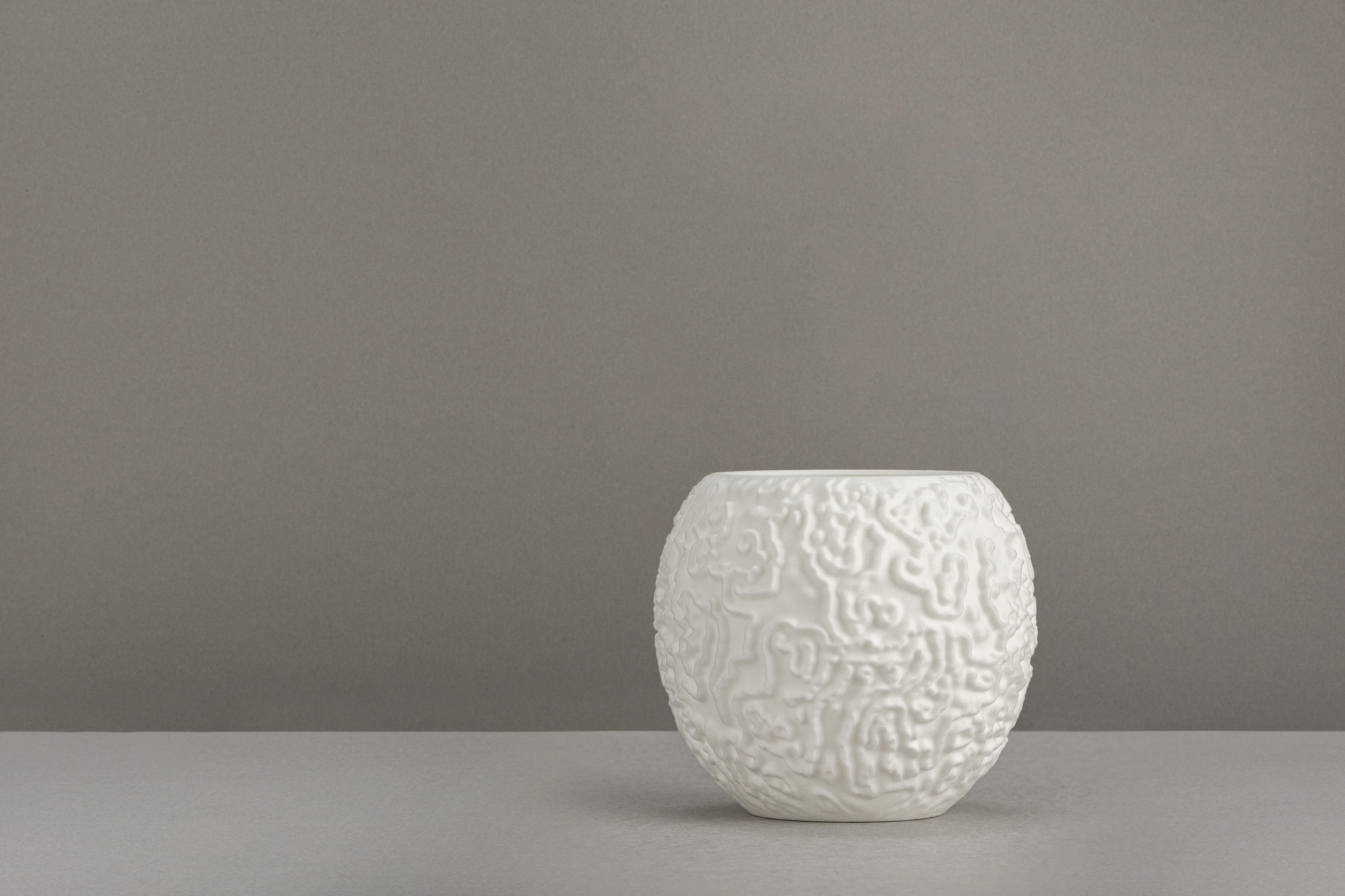 Decorative suggestion for Alluvial Crush: Tealight holder featuring intricate glyphs from reaction-diffusion simulation. Adds a visual symphony of mesmerizing patterns - variant Original (Elegant white), an original product by Cosmic Jubilee (2 of 3) - presented as a tealight, switched off.