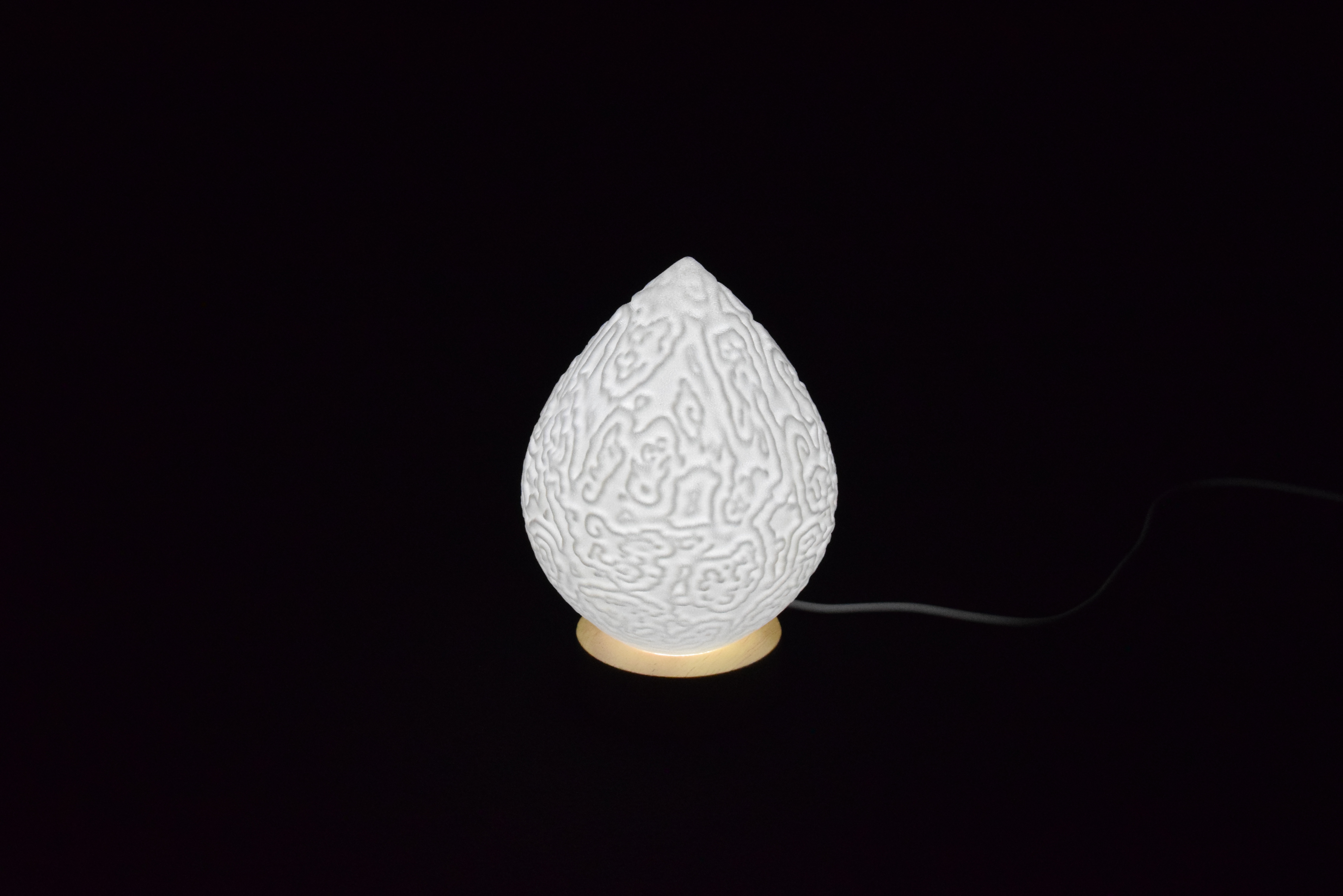 Decorative suggestion for Cosmic Drop: Desktop light with cosmic design. Encapsulates the beauty of the cosmos - variant Alluvial Crush (Elegant white), an original product by Cosmic Jubilee (1 of 5) - presented as desktop, table, or freestanding light, switched on.