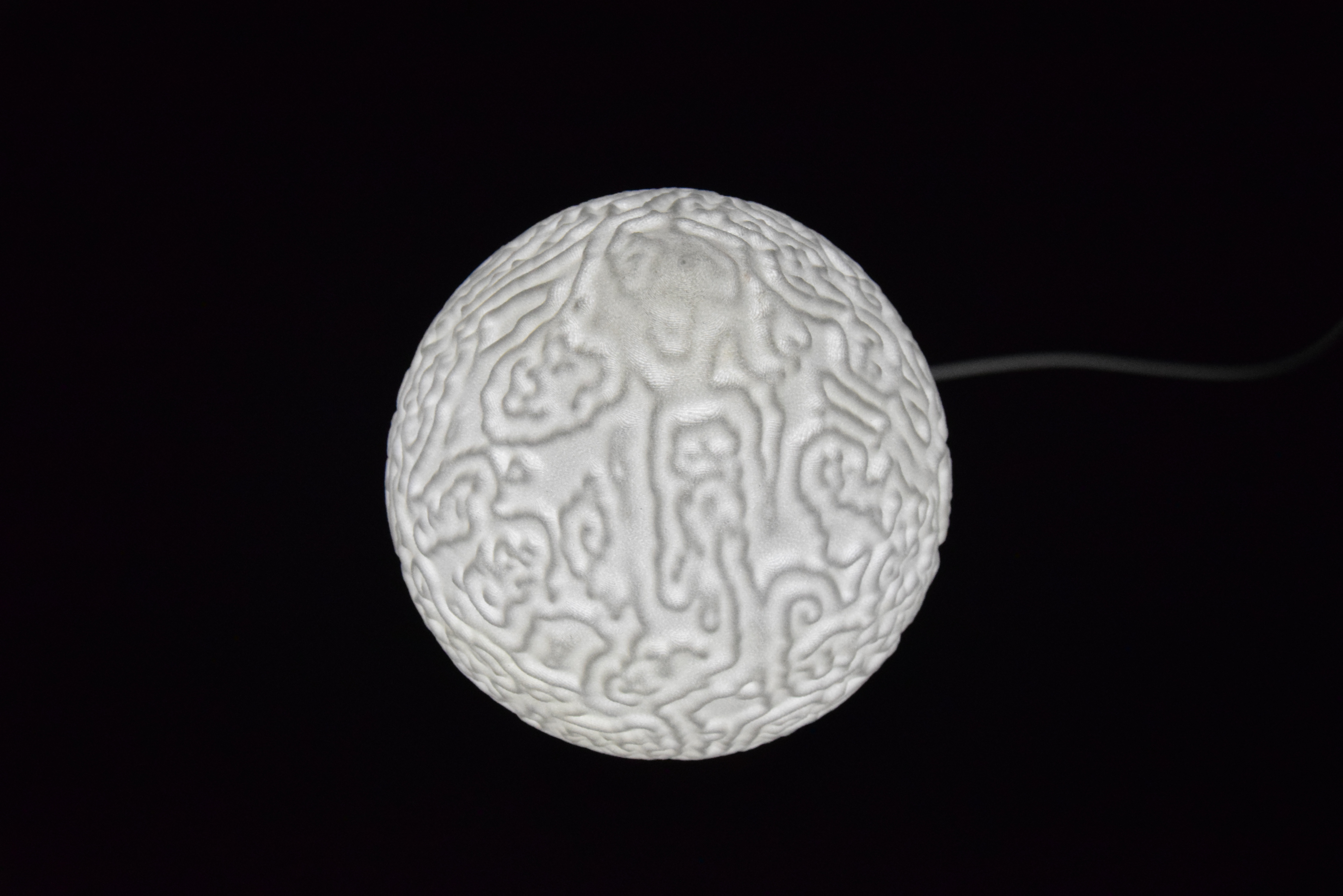 Decorative suggestion for Cosmic Drop: Desktop light with cosmic design. Encapsulates the beauty of the cosmos - variant Alluvial Crush (Elegant white), an original product by Cosmic Jubilee (3 of 5) - presented as desktop, table, or freestanding light, switched on.