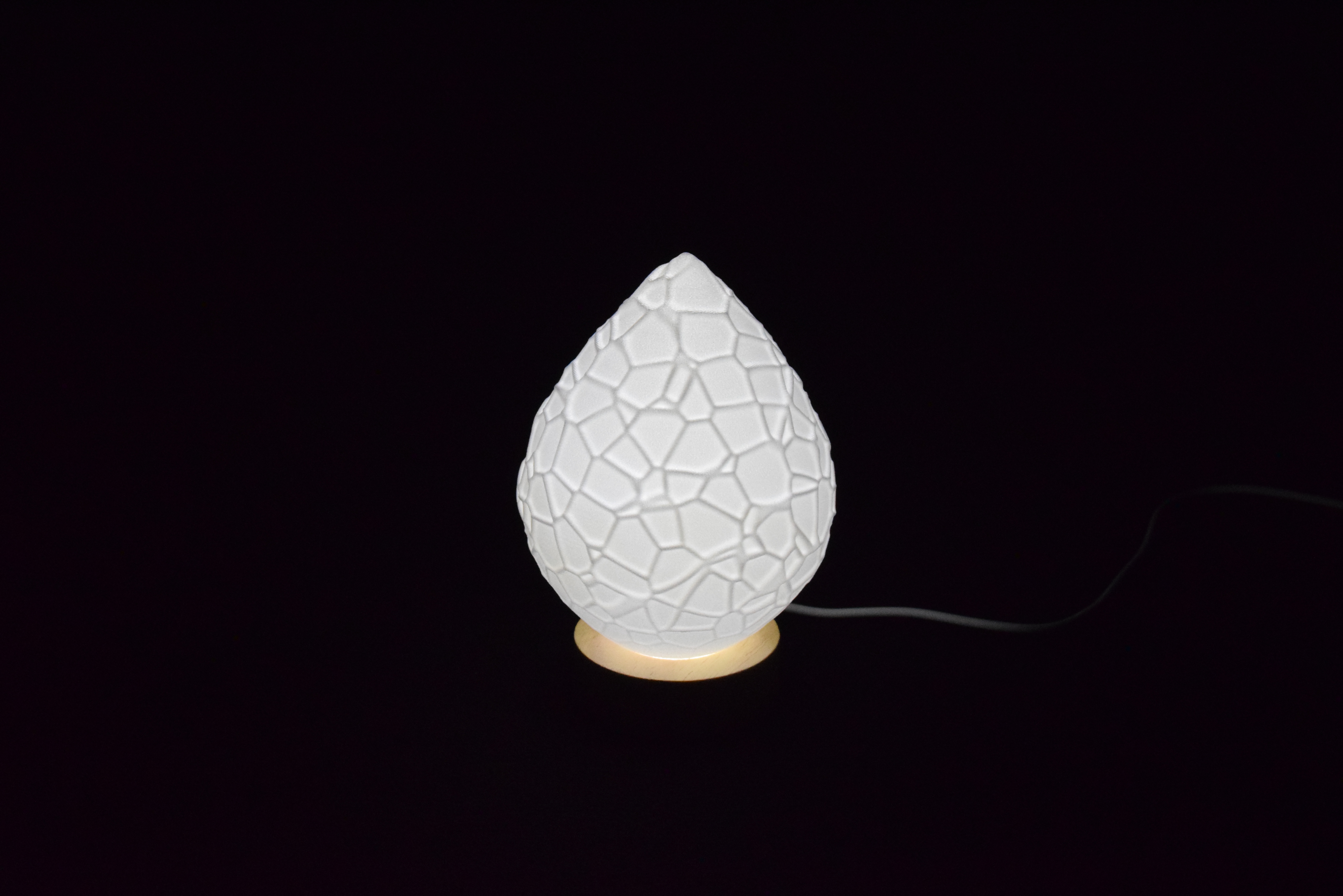 Decorative suggestion for Cosmic Drop: Desktop light with cosmic design. Encapsulates the beauty of the cosmos - variant Petrified Shallows (Elegant white), an original product by Cosmic Jubilee (1 of 5) - presented as desktop, table, or freestanding light, switched on.