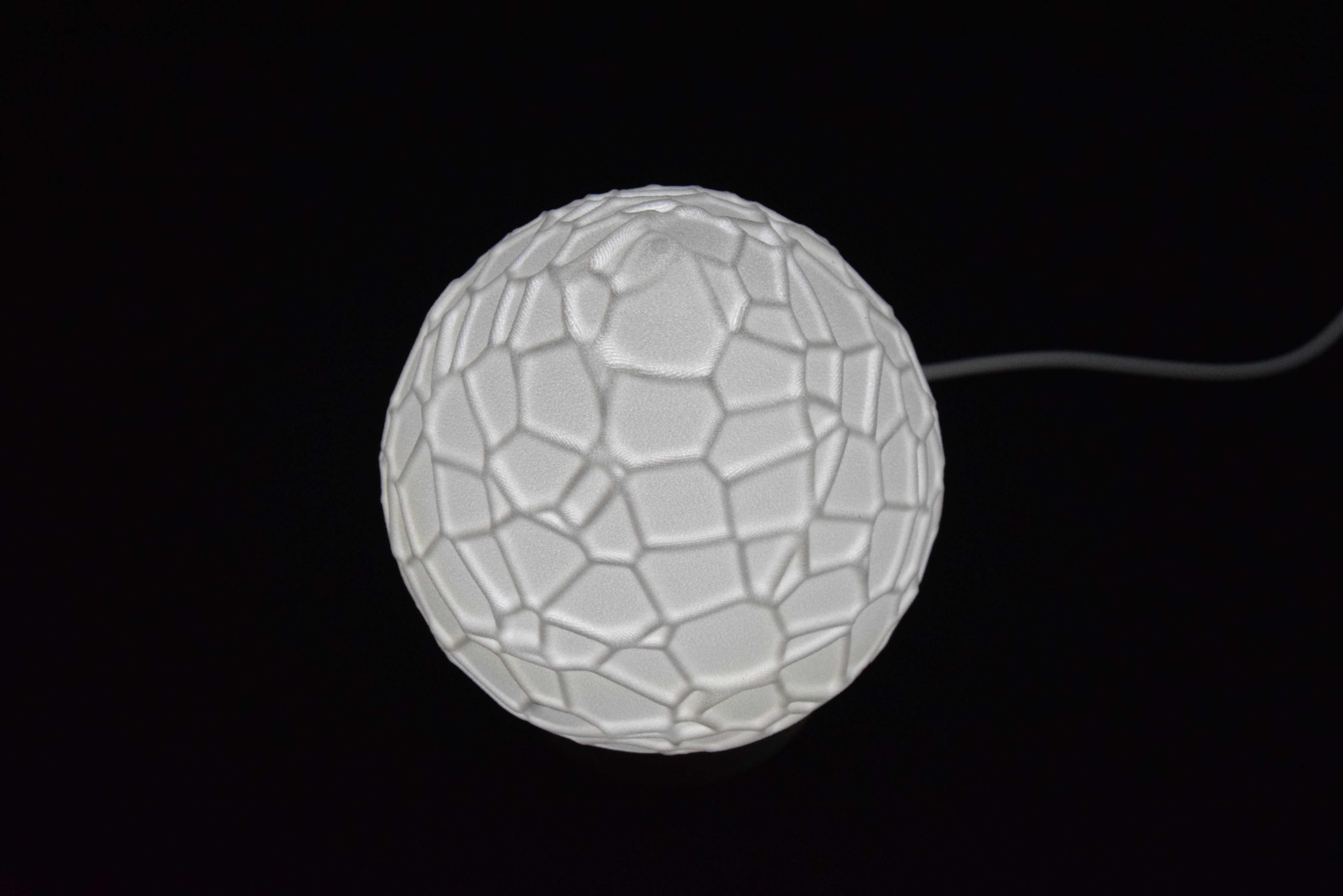 Decorative suggestion for Cosmic Drop: Desktop light with cosmic design. Encapsulates the beauty of the cosmos - variant Petrified Shallows (Elegant white), an original product by Cosmic Jubilee (3 of 5) - presented as desktop, table, or freestanding light, switched on.