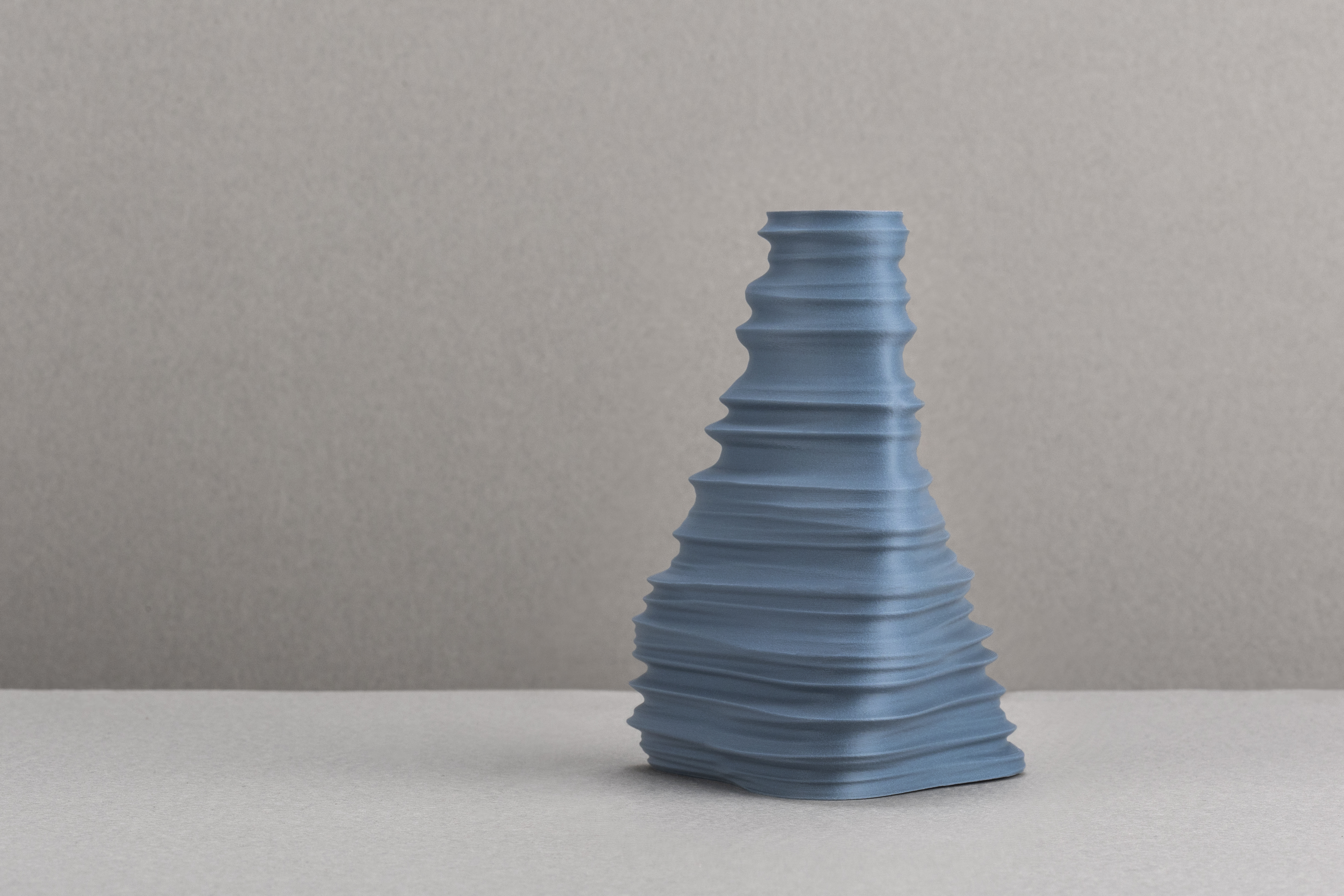 Decorative suggestion for Igneous Brim: Decorative (non-water) vase inspired by geological wonders. Textured design cradling dry flowers or standing alone as a decorative element - variant Lake Blue (Crystaline lake water blue), an original product by Cosmic Jubilee (1 of 2) - presented as a decorative (non-water) vase or standalone showpiece.