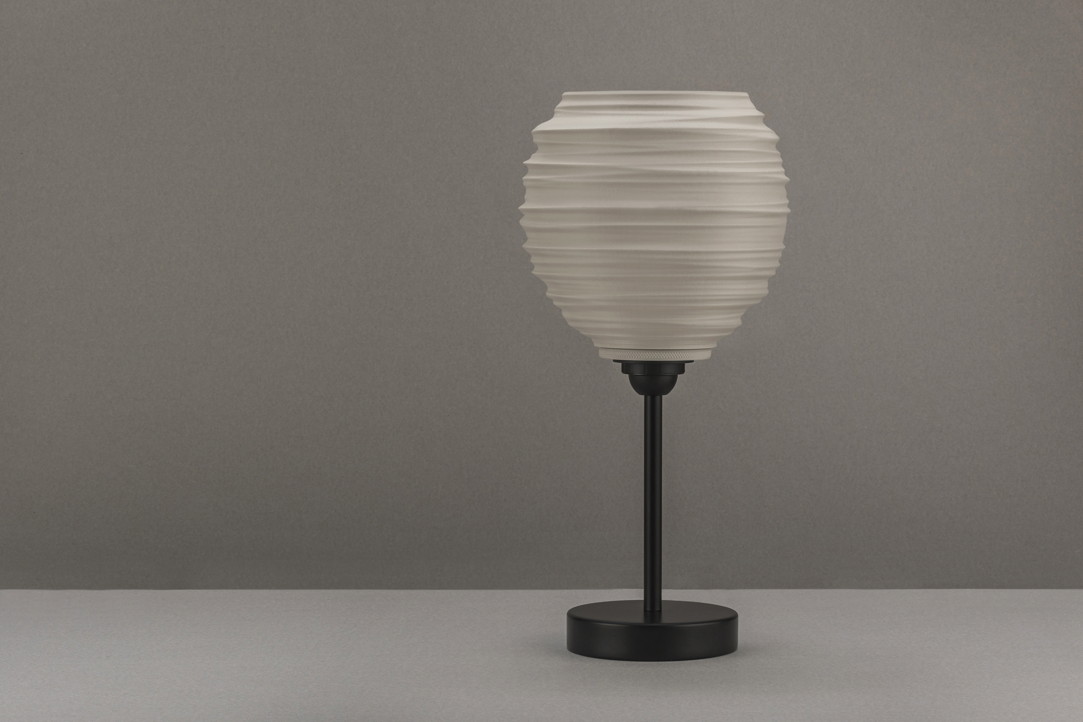 Decorative suggestion for Magma Shroud: Pendant lampshade mirroring tumultuous magma flow. Adds an elemental touch to modern decor - variant Original (Creme and beige diffuse light), an original product by Cosmic Jubilee (4 of 6) - presented as desktop, table, or freestanding light, switched off.