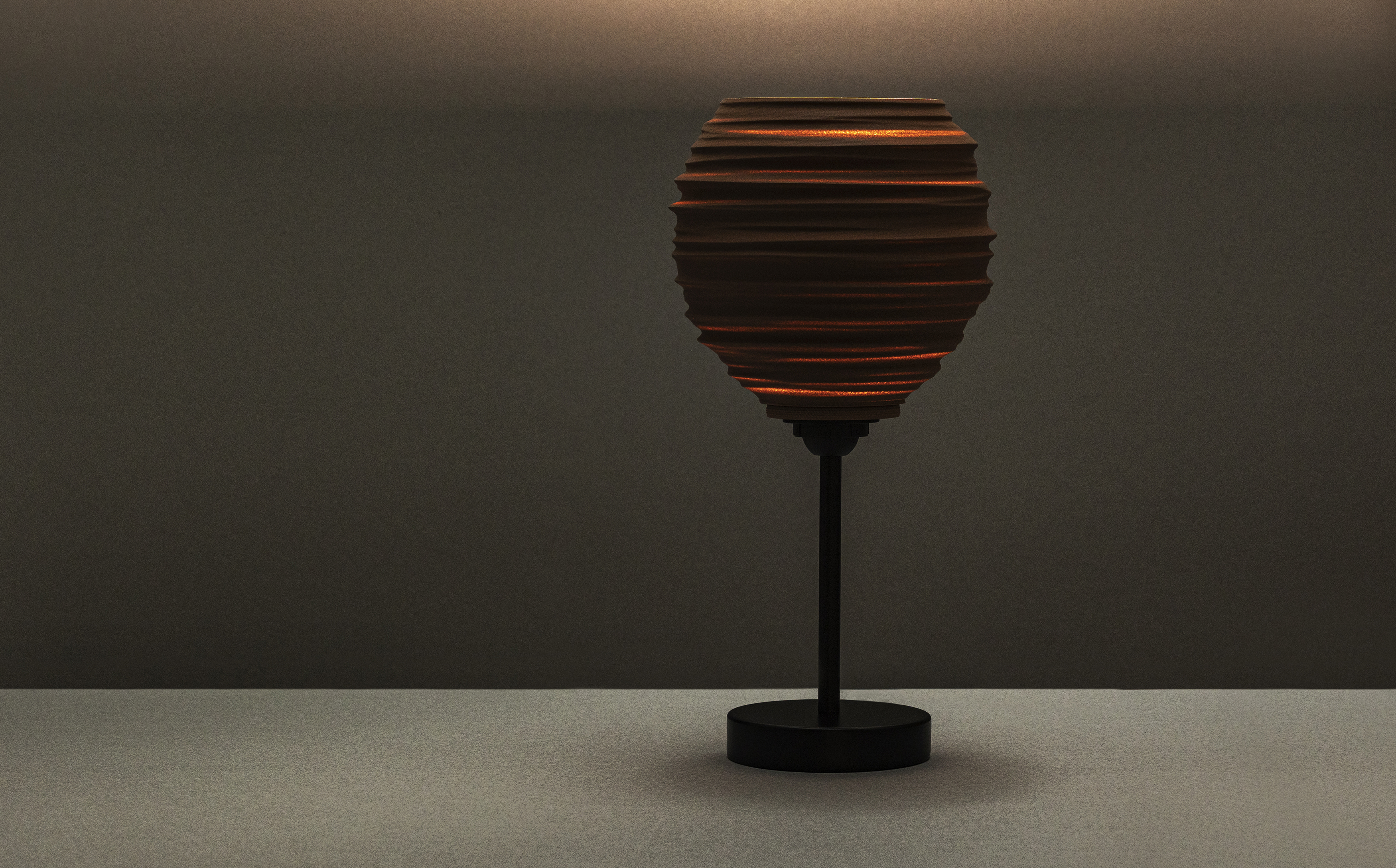 Decorative suggestion for Magma Shroud: Pendant lampshade mirroring tumultuous magma flow. Adds an elemental touch to modern decor - variant Stone Red (Grainy textured stone red spotlight), an original product by Cosmic Jubilee (3 of 6) - presented as desktop, table, or freestanding light, switched on.