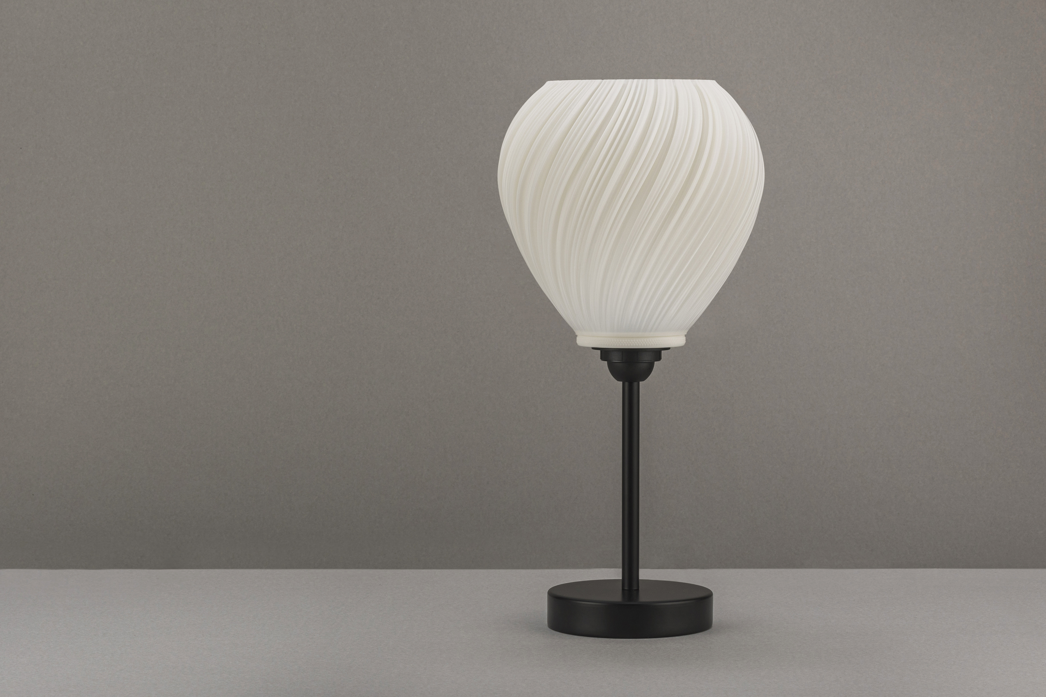 Decorative suggestion for Pellucid Sweep: Spiraling pleats pendant lampshade for a balletic light play. Transforms environments with mesmerizing beauty - variant Original (Milky white), an original product by Cosmic Jubilee (4 of 6) - presented as desktop, table, or freestanding light, switched off.