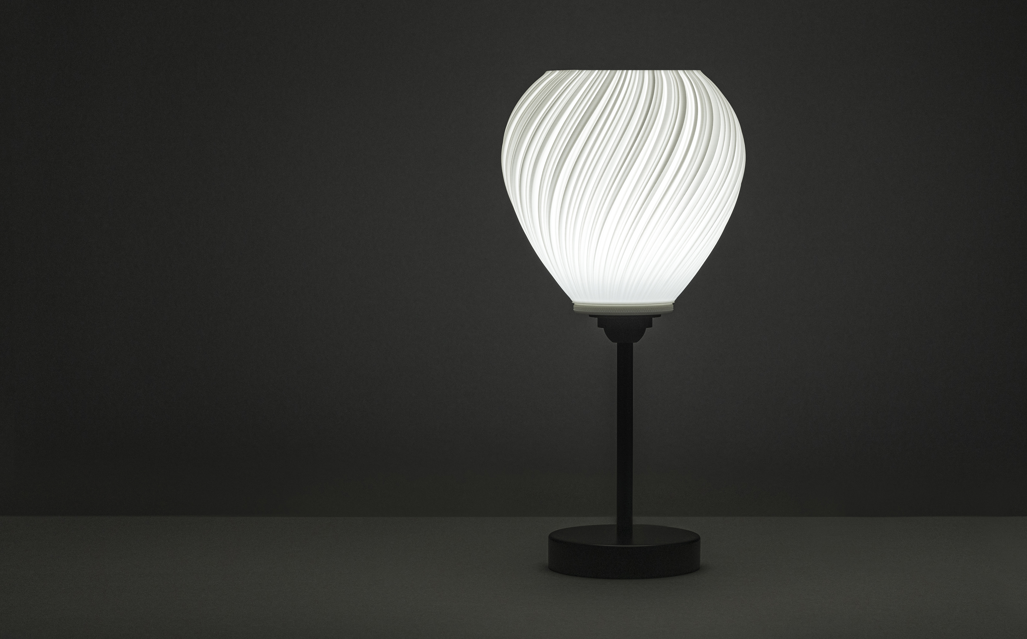 Decorative suggestion for Pellucid Sweep: Spiraling pleats pendant lampshade for a balletic light play. Transforms environments with mesmerizing beauty - variant Original (Milky white), an original product by Cosmic Jubilee (3 of 6) - presented as desktop, table, or freestanding light, switched on.