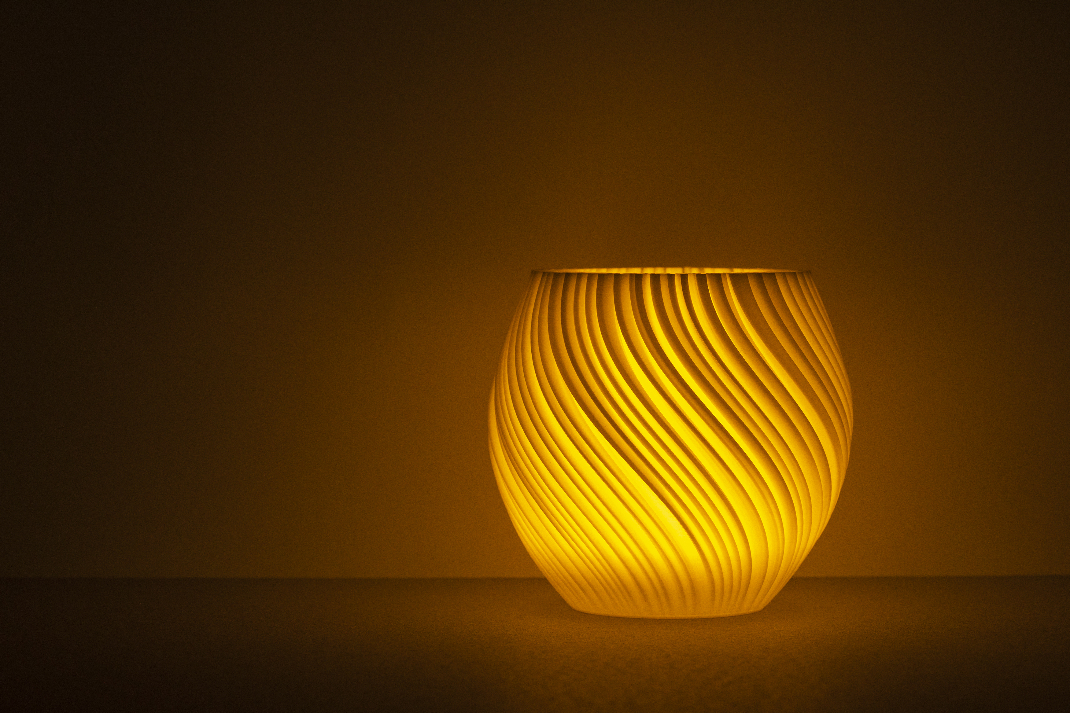 Decorative suggestion for Pellucid Sweep: Tealight holder with flush, velvety filaments. Offers a crystalline aspect to any elegant setting - variant Midnight (Mysterious translucent black), an original product by Cosmic Jubilee (1 of 3) - presented as a tealight, switched on.
