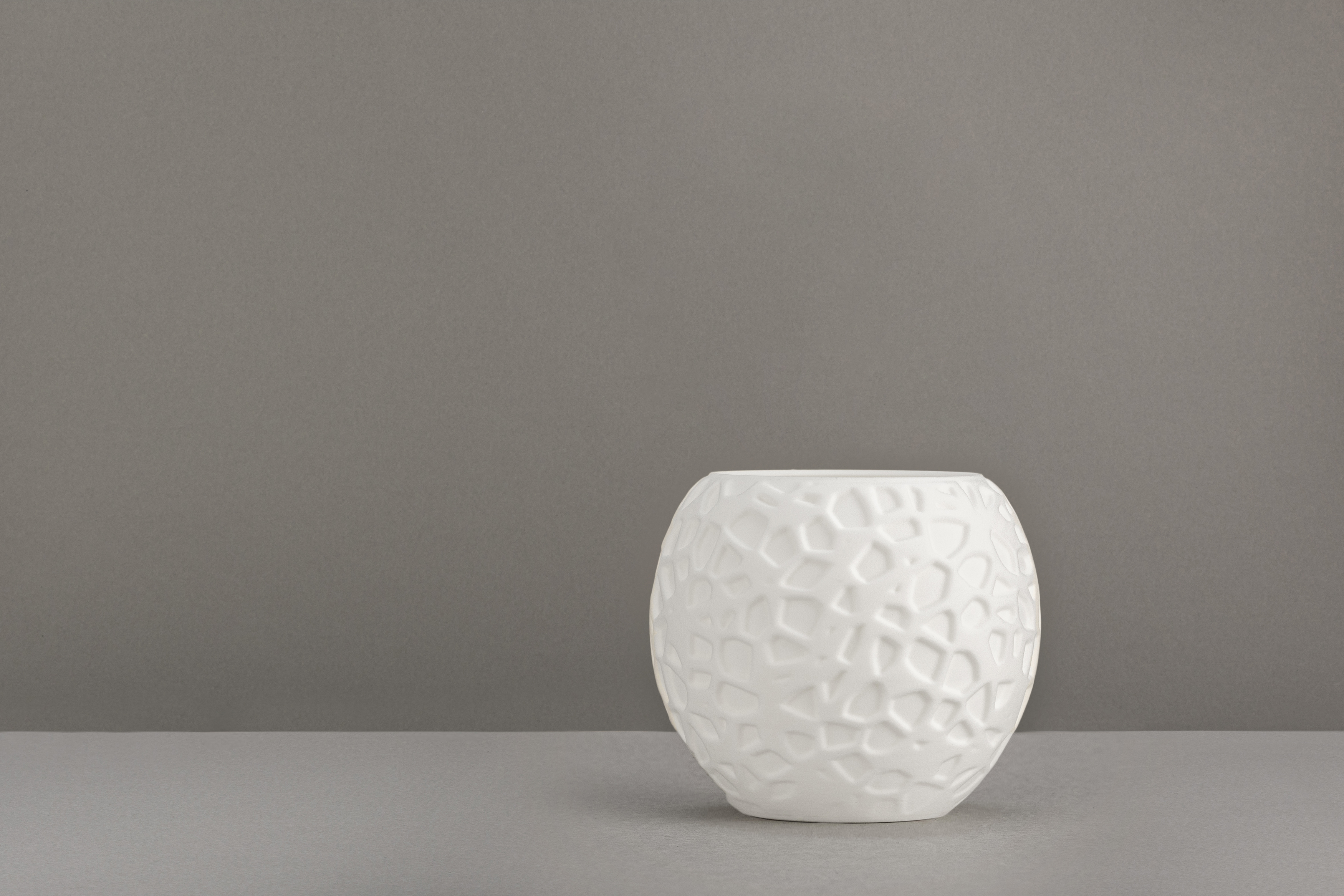 Decorative suggestion for Petrified Shallows: Voronoi pattern tealight holder echoing life's journeys. Warm glow casting memories and paths in light - variant Original (Elegant white), an original product by Cosmic Jubilee (2 of 3) - presented as a tealight, switched off.