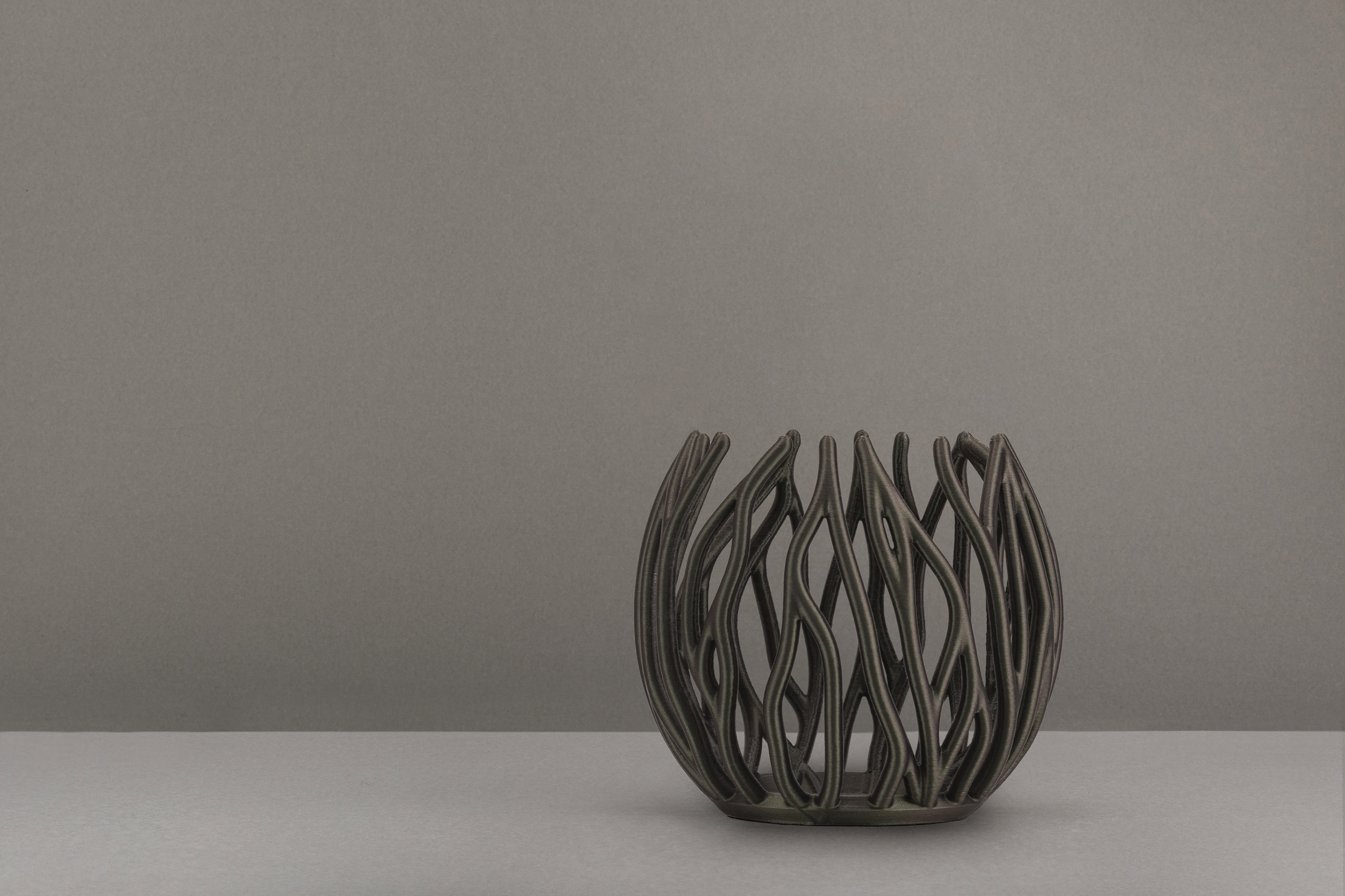 Decorative suggestion for Twinkling Bloom: Elegant tealight holder with organic, floral-inspired design. Mesmerizing shadow play for subtle elegance and ambiance - variant Oak (Changing deep greens and browns), an original product by Cosmic Jubilee (2 of 3) - presented as a tealight, switched off.